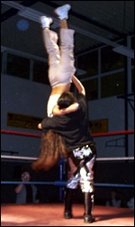 Wesna shows her strength as she holds her opponent upside down before suplexing her to the mat.